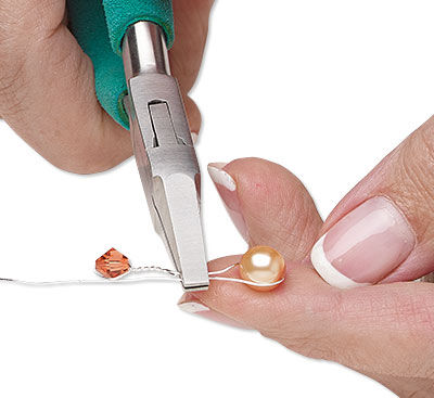 Pliers holding twisted wire with bead
